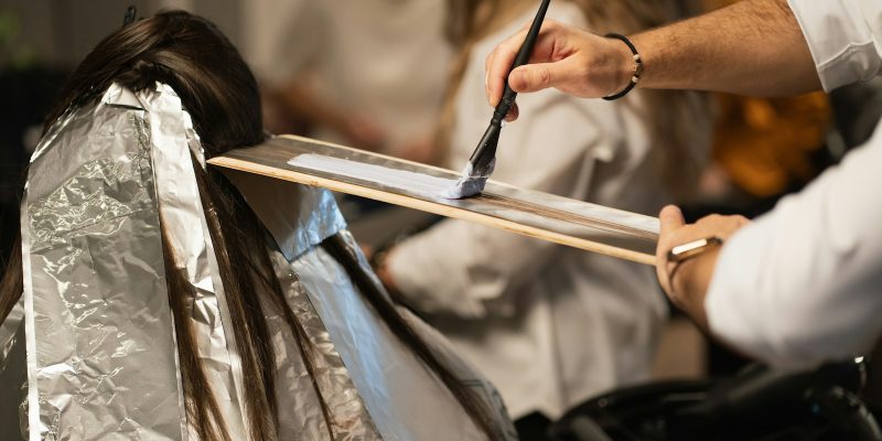 a man cutting a woman's hair with a pair of scissors